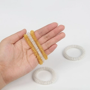 Golden and silver sensory spring massage rings for acupressure therapy and stress relief