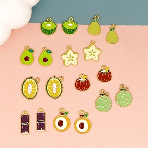 Flat lay of colorful fruit enamel charms like kiwi and pear for DIY jewelry making