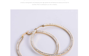 Macro detail of golden square-cut titanium steel hoop earrings with crystal pavé setting