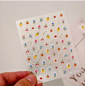 Detail view of 3D embossed fruit and floral nail art stickers with gold foil edges