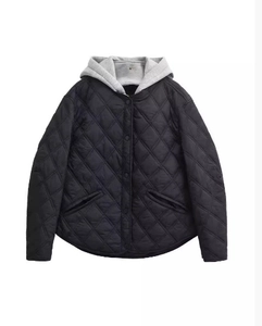 Detail view of black quilted jacket featuring diamond stitching and grey contrast hood