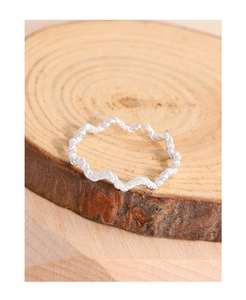 Detail shot of a silver twisted rope ring featuring an adjustable open band on wood