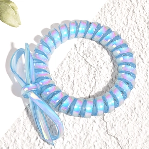 Gros plan d'un chouchou spirale bleu iridescent avec un détail de nœud assorti