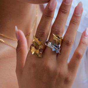 Détails de bagues superposées en forme de feuilles d'or et d'argent sur la main