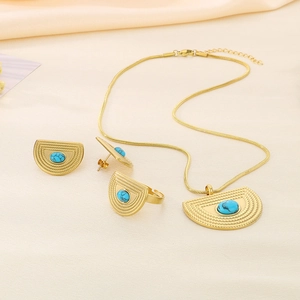 Dettaglio del set di gioielli a ventaglio dorato con pietre blu su tessuto beige