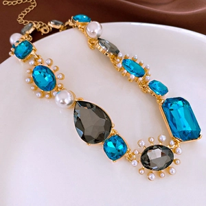 Détail d'un collier vintage avec cristaux bleus, perles et métal doré élégant