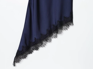 Detailed close-up of navy satin dress featuring black eyelash lace trim and silky texture