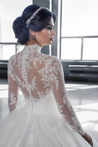 Détail de robe de mariée en dentelle blanche avec boutons élégants et dos brodé