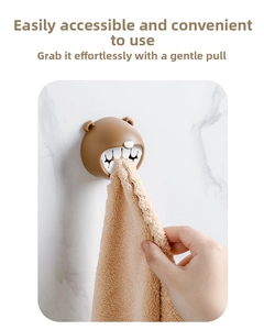 Detail view of brown bear towel holder showing the secure grip on a beige cloth