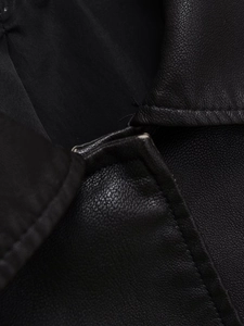 Détail macro d'une veste en similicuir noir montrant la texture et les coutures du col