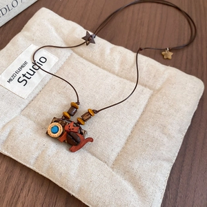Close-up of handmade wooden cat necklace with coffee bean and star charm details