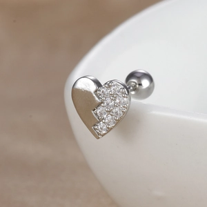 Gros plan d'un piercing hélix cœur en argent avec zircons et fermoir à vis