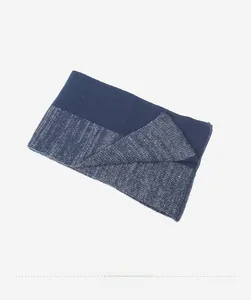 Vista dall'alto dello scaldacollo in maglia spessa con trame di filato blu scuro e misto