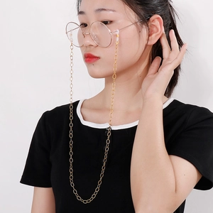 Detail of gold metal link eyewear chain worn by model for glasses protection