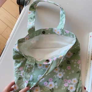 Close-up of floral cotton tote bag with vintage bronze snap button and canvas lining