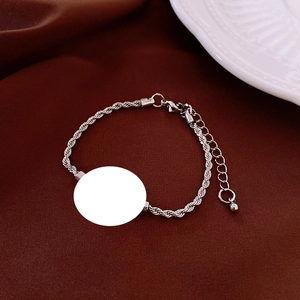 Macro view of silver twisted chain bracelet with a white sublimation round pendant charm