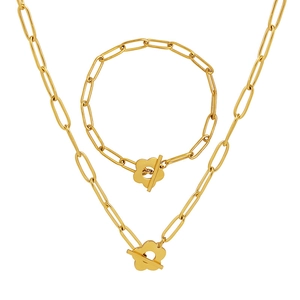 Golden paperclip chain jewelry set with floral OT toggle clasp on white background