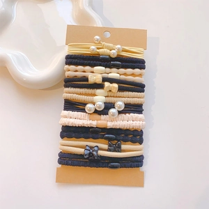 Close-up of assorted elastic hair ties with pearls and bows on a display card