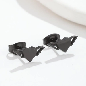 Macro shot of matte black heart earrings with wings in a minimalist geometric style