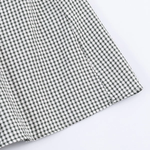Detailed macro view of green and white checkered cotton fabric with woven texture