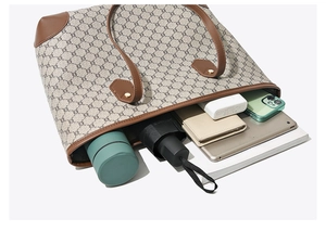 Flat lay view showing large capacity interior of beige monogram tote bag with essentials
