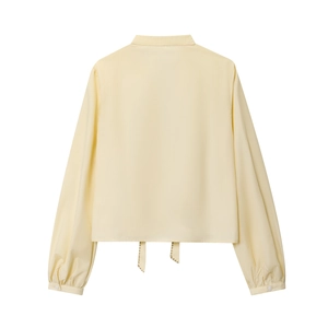 Detail of light yellow poplin shirt featuring a stylish back tie-knot hem and button cuffs