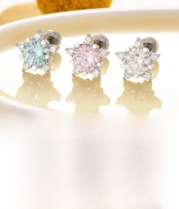 Detailed set of three star-shaped zircon earrings in light blue, pink and clear stones