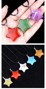 Macro detail of various colorful star-shaped natural crystal necklaces with black cords