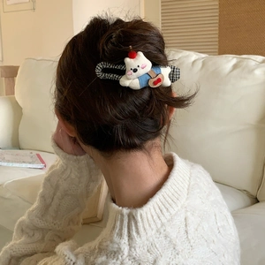 Detail of white plush bear hair clip with red hat on model in back view hairstyle