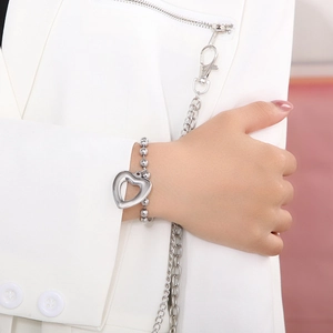 Close-up of polished silver stainless steel hollow heart pendant necklace and bracelet