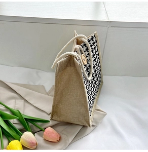 Detail of houndstooth canvas tote bag with rustic jute sides and large wooden button buckle