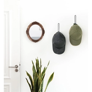 L-shaped metal baseball cap rack mounted on white wall with modern minimalist decor