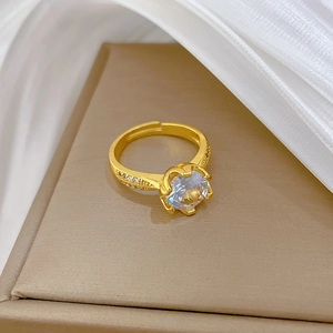 Close-up of gold-plated open ring showing prong-set zircon and sparkling center stone