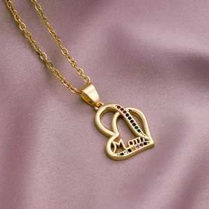 Detail of gold Mom pendant necklace with multi-colored crystals on purple satin fabric