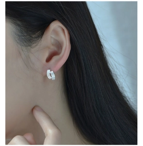Close-up of S925 sterling silver multi-layer wavy line hoop earrings worn by a model