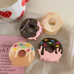 Set of four donut-shaped acetate hair claws with colorful sprinkles in soft pastel tones