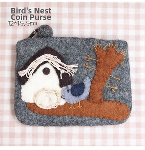 Detail of wool felt bird nest coin purse with bird embroidery and zipper ball