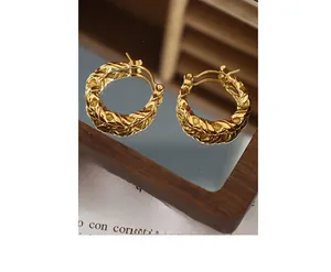 Macro view of gold-plated twisted rope hoop earrings with vintage textured surface
