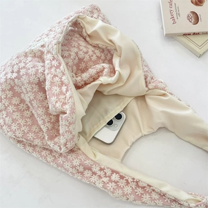 Detailed view of pink mesh tote bag with daisy embroidery and internal phone pocket