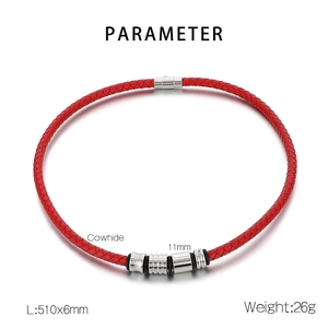 Detail view of red braided leather cord bracelet with silver charms and magnetic clasp
