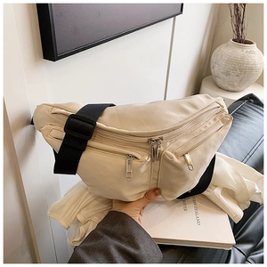 Close-up of cream nylon crossbody bag with adjustable black strap in a modern home setting