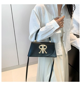 Detail of black trapezoid handbag with golden RR logo and metal hardware accessories