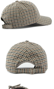 Detailed view of houndstooth baseball cap showing adjustable metal buckle and tweed texture