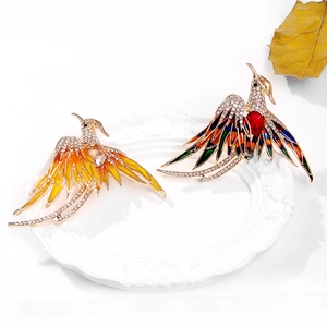 Close-up of luxury phoenix brooches with colorful enamel and sparkling crystal inlay