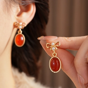 Details von Vintage-Bogenohrringen mit weißer Perle und rotem ovalem Edelstein