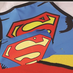 Detail of Superman S-shield logo printed on colorful beer festival apron fabric