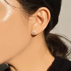 Close-up of minimalist four-prong square zircon stud earring worn on model's ear