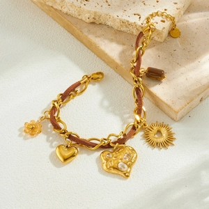 Golden chain and brown cord bracelet with heart, sun pendants and crystal charms