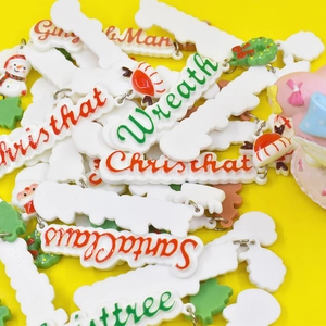 Christmas themed resin pendants with Merry Christmas and Santa lettering on yellow background