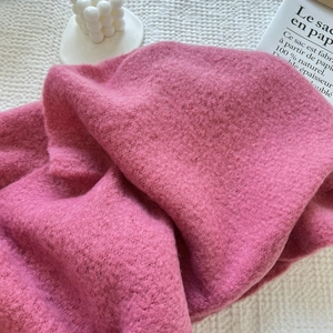 Close-up of soft pink faux cashmere scarf texture with fluffy woven material detail